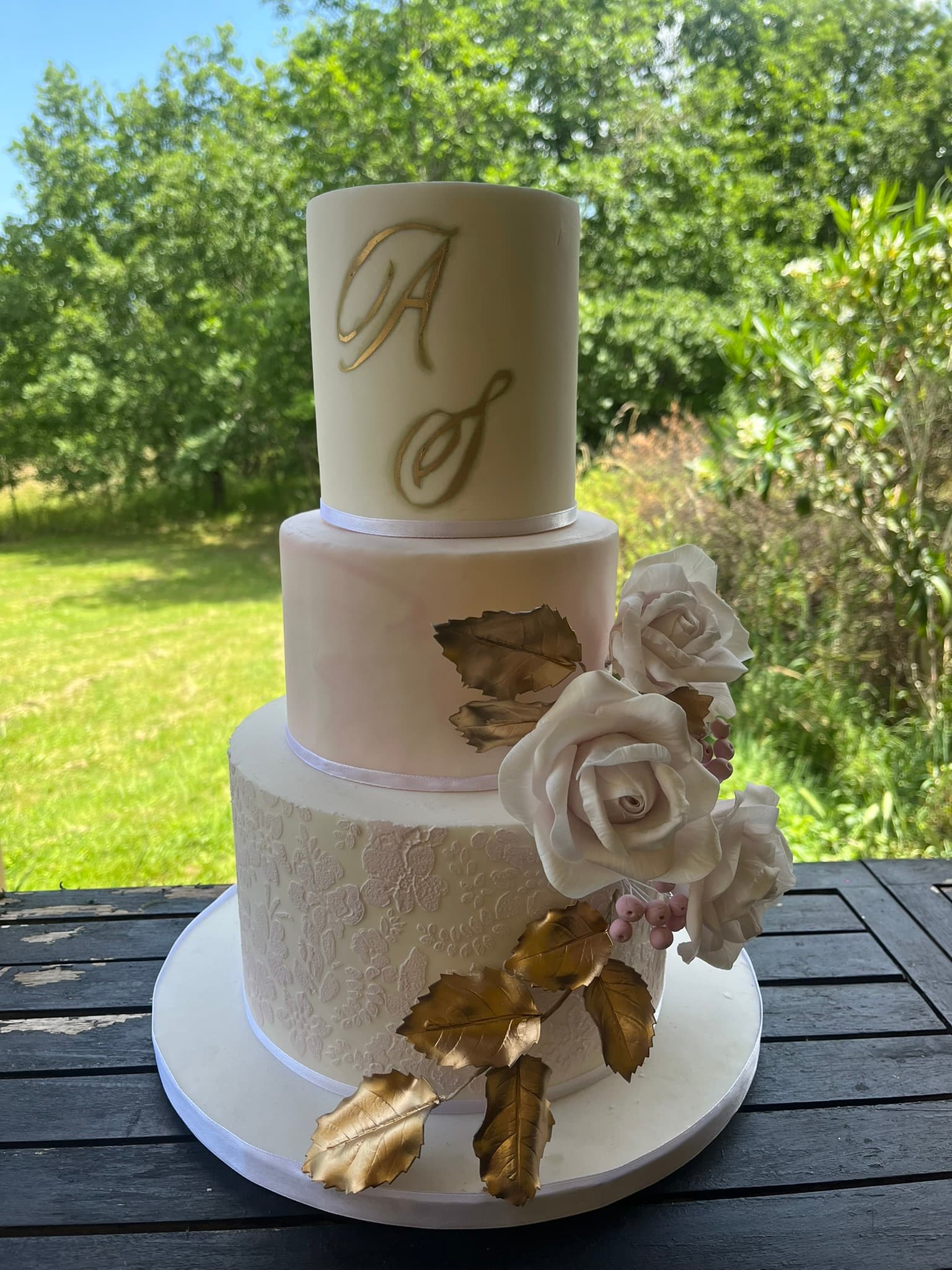 Wedding cake monogramme doré Wedding cake 3 étages avec monogramme doré, roses en sucre et dentelle pour mariage à Montauban